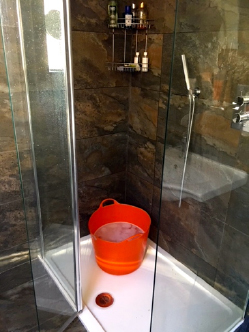 A bucket in a shower cubicle